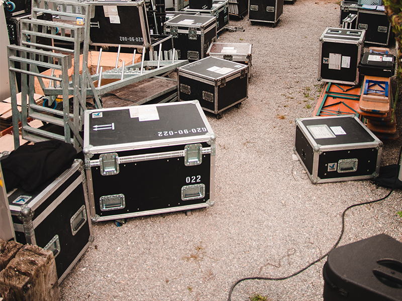 Numerous flight cases are strewn across the concrete floor